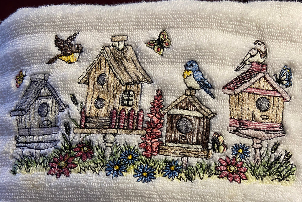 Embroidered design of birdhouses and flowers on a textured fabric background